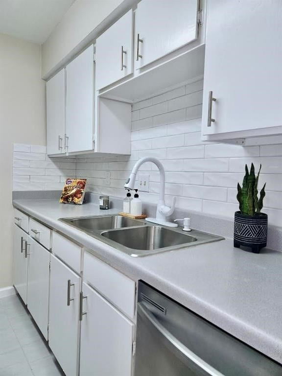 kitchen with decorative backsplash, white cabinetry, sink, and dishwasher