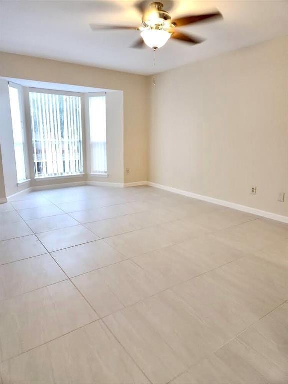 4641 Wild Indigo St Unit 449, Houston, TX 77027 - spare room with light tile patterned floors, a ceiling fan, and baseboards