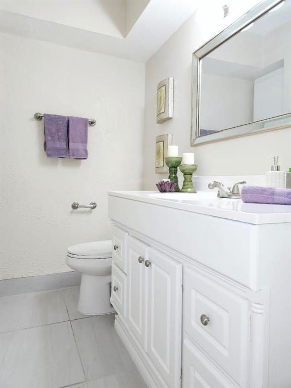 4641 Wild Indigo St Unit 449, Houston, TX 77027 - half bath featuring vanity, toilet, baseboards, and tile patterned flooring