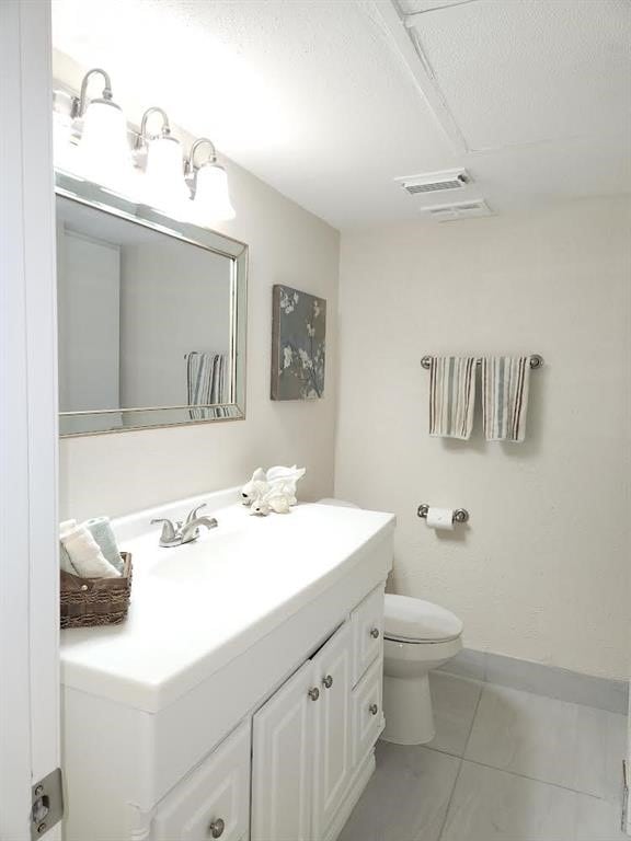 bathroom with vanity, toilet, and tile patterned floors