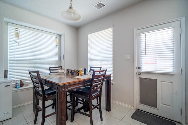 dining space with light tile patterned flooring and a wealth of natural light