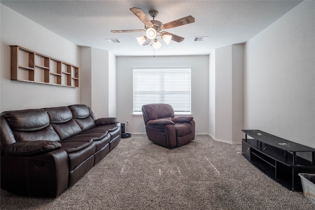 living room with ceiling fan, carpet, and a textured ceiling