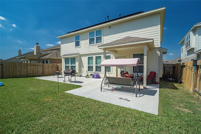 back of house featuring a lawn and a patio area