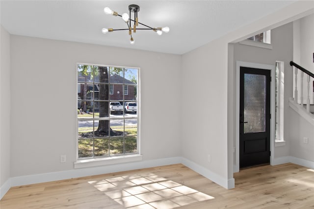 interior space with light hardwood / wood-style floors and a notable chandelier