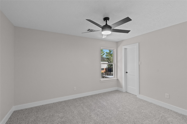 carpeted spare room featuring a textured ceiling and ceiling fan