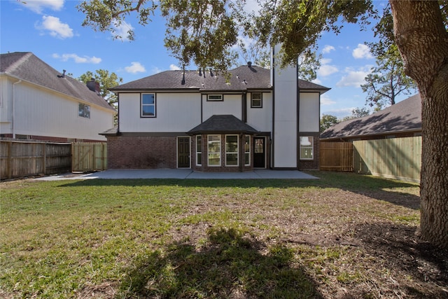 back of house with a lawn and a patio area