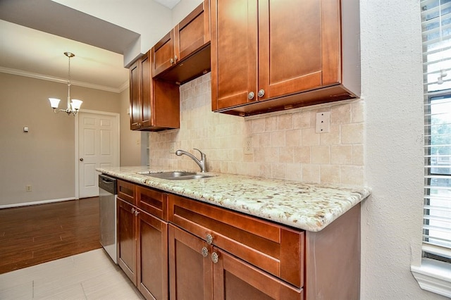 kitchen with hanging light fixtures, sink, light stone counters, and plenty of natural light