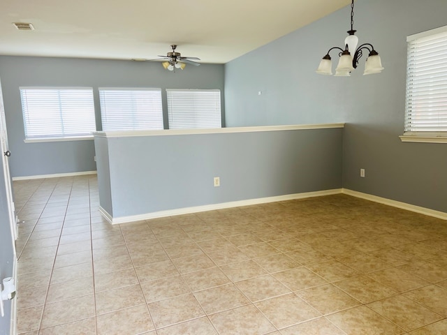 spare room featuring light tile patterned flooring and ceiling fan with notable chandelier