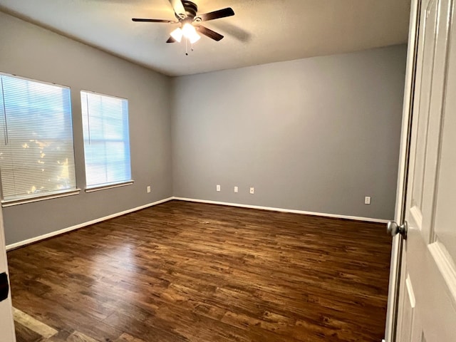 spare room with dark wood-type flooring and ceiling fan