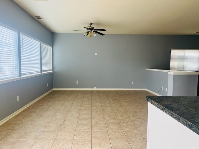 unfurnished living room featuring light tile patterned floors and ceiling fan