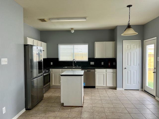 kitchen with appliances with stainless steel finishes, a kitchen island, a wealth of natural light, and sink