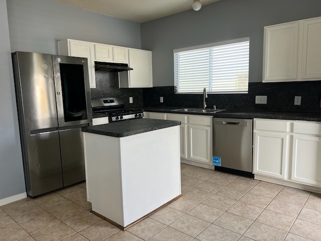 kitchen with a kitchen island, decorative backsplash, white cabinets, sink, and appliances with stainless steel finishes