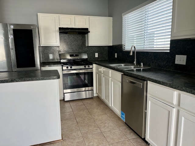 kitchen featuring stainless steel appliances, sink, light tile patterned flooring, white cabinetry, and backsplash