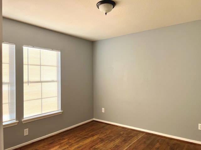 spare room featuring dark hardwood / wood-style floors and a wealth of natural light