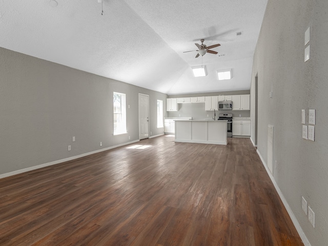 unfurnished living room with a textured ceiling, dark hardwood / wood-style flooring, sink, lofted ceiling, and ceiling fan