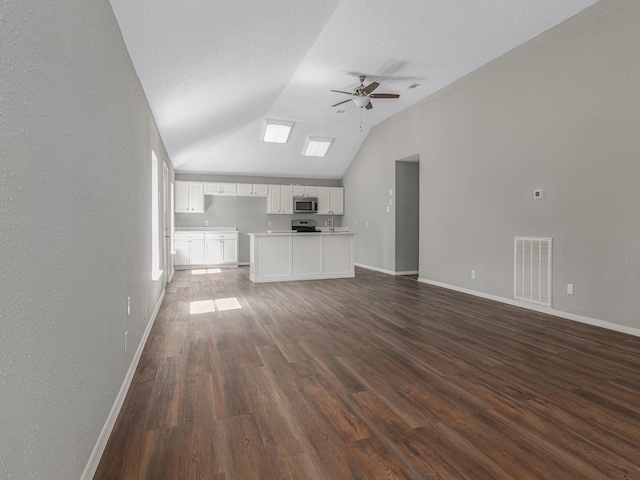 unfurnished living room featuring a textured ceiling, dark hardwood / wood-style floors, ceiling fan, and vaulted ceiling