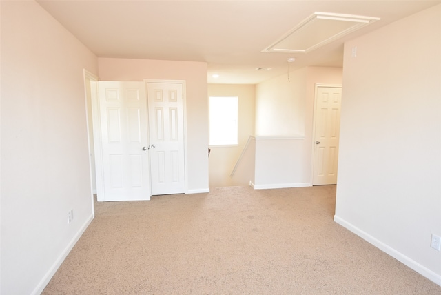 unfurnished bedroom featuring light carpet and a closet