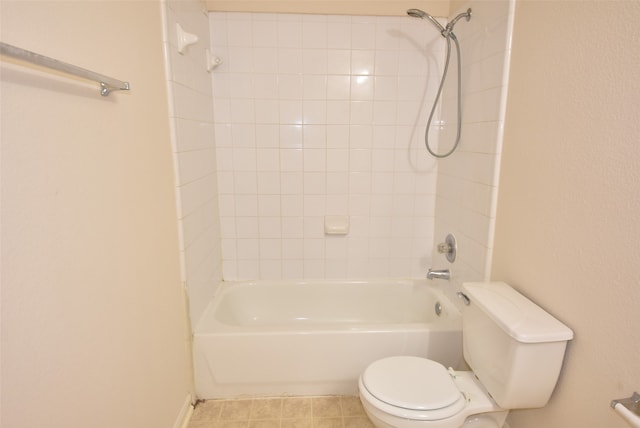 bathroom with toilet, tiled shower / bath, and tile patterned flooring