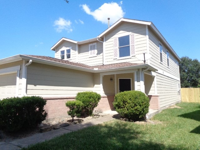 view of property featuring a front lawn and a garage