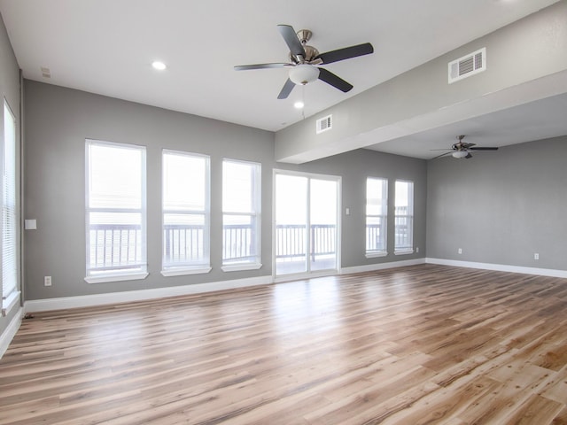 spare room featuring ceiling fan, baseboards, light wood-style floors, and visible vents