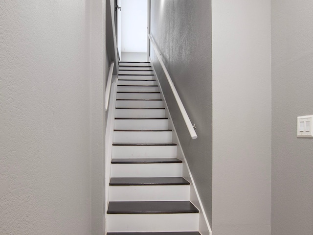 stairs featuring a textured wall