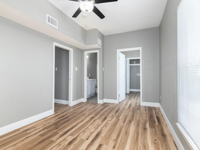 unfurnished bedroom featuring a ceiling fan, light wood-type flooring, baseboards, ensuite bath, and visible vents
