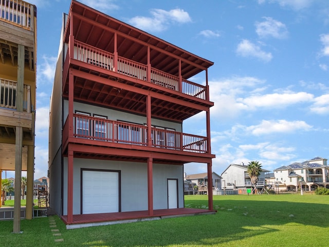 back of property with a deck, a garage, and a lawn