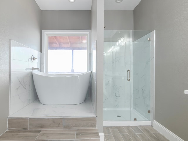 bathroom featuring separate shower and tub