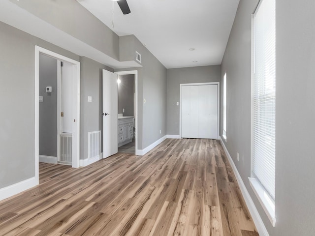 unfurnished bedroom featuring a closet, wood finished floors, visible vents, and baseboards