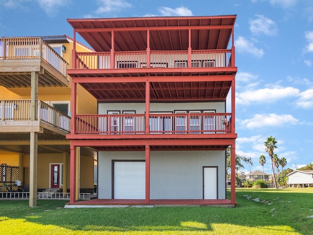 rear view of property with a yard, a deck, and a garage