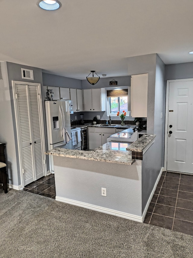 kitchen with sink, kitchen peninsula, stainless steel refrigerator with ice dispenser, dark colored carpet, and white range with electric cooktop