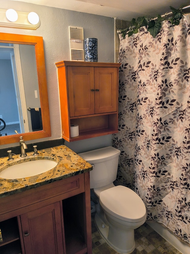 bathroom featuring curtained shower, vanity, and toilet