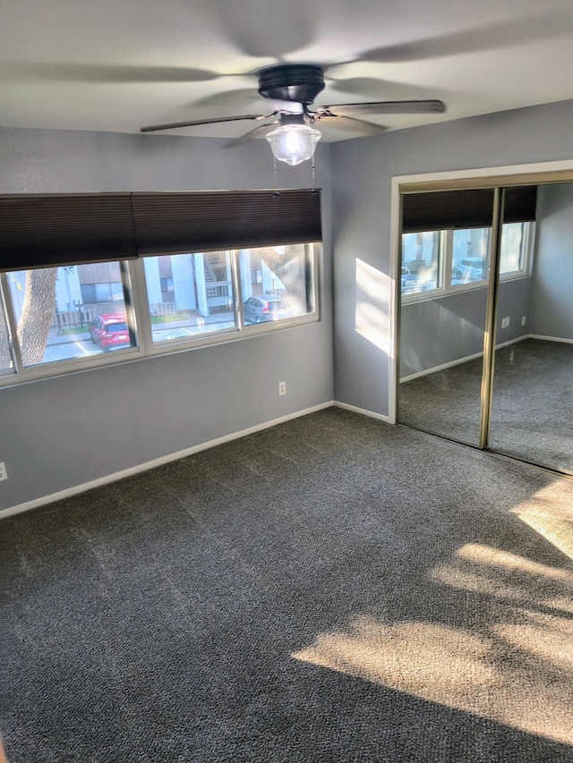 unfurnished bedroom featuring ceiling fan, carpet floors, a closet, and multiple windows