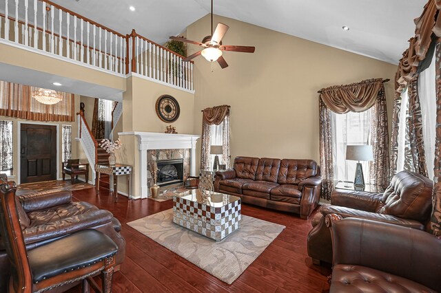 living room with ceiling fan, a fireplace, dark hardwood / wood-style floors, and high vaulted ceiling