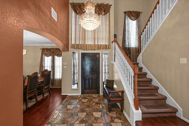 entrance foyer featuring ornamental molding, a chandelier, and dark hardwood / wood-style flooring