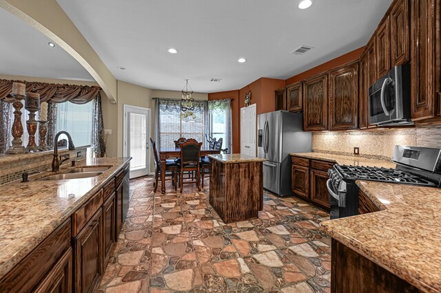 kitchen featuring a healthy amount of sunlight, a center island, stainless steel appliances, and backsplash