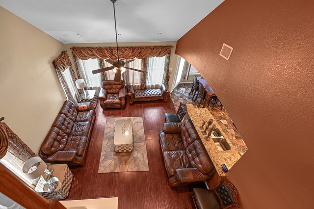 living room with dark wood-type flooring and ceiling fan