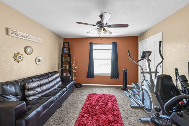 exercise area with ceiling fan, carpet floors, and a textured ceiling