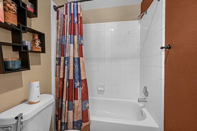 bathroom featuring shower / tub combo and toilet