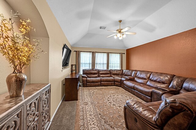 living room with ceiling fan, carpet floors, and vaulted ceiling