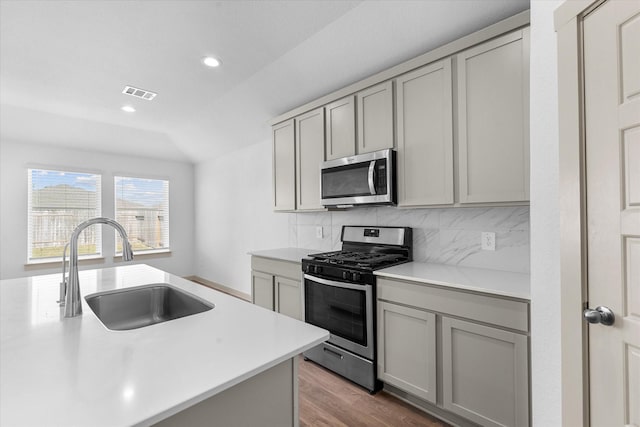 kitchen with gray cabinets, light countertops, visible vents, stainless steel appliances, and a sink