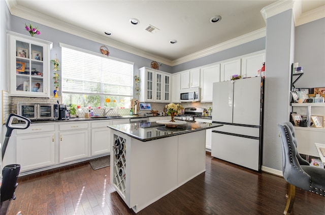 kitchen featuring white cabinetry, stainless steel appliances, dark wood-type flooring, and a kitchen island