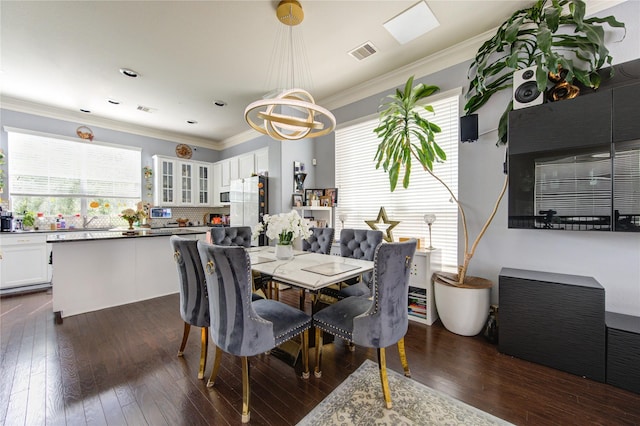 dining space with dark wood-style flooring, a chandelier, and ornamental molding
