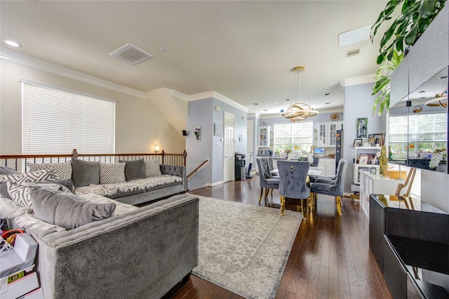 living room with a notable chandelier, ornamental molding, and dark hardwood / wood-style flooring