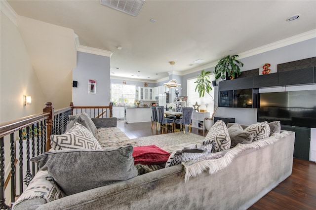 living room with wood finished floors and crown molding