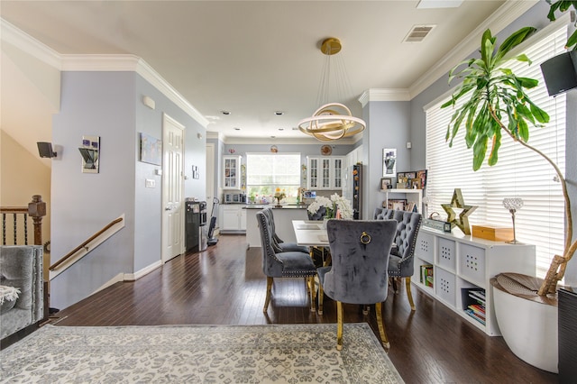 dining space with ornamental molding and dark hardwood / wood-style floors