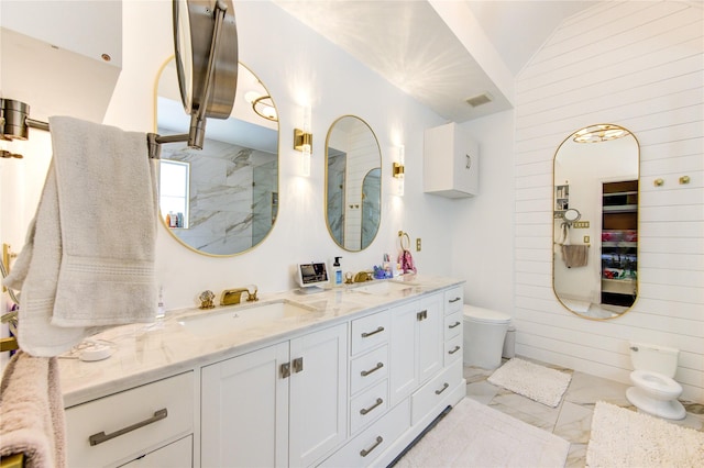 bathroom featuring marble finish flooring, vaulted ceiling, double vanity, a marble finish shower, and wood walls