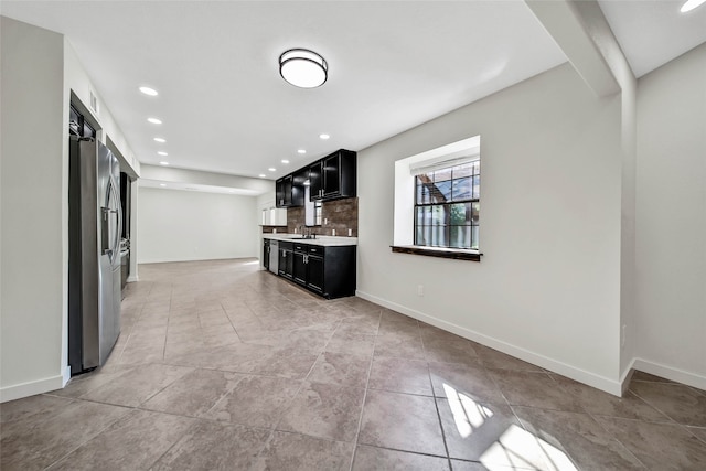 unfurnished living room featuring light tile patterned floors and sink