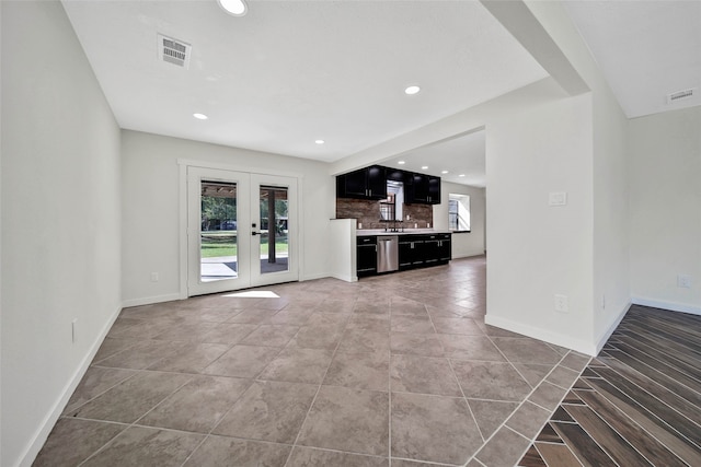 unfurnished living room featuring french doors and sink