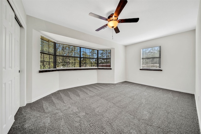 carpeted spare room featuring ceiling fan and a healthy amount of sunlight